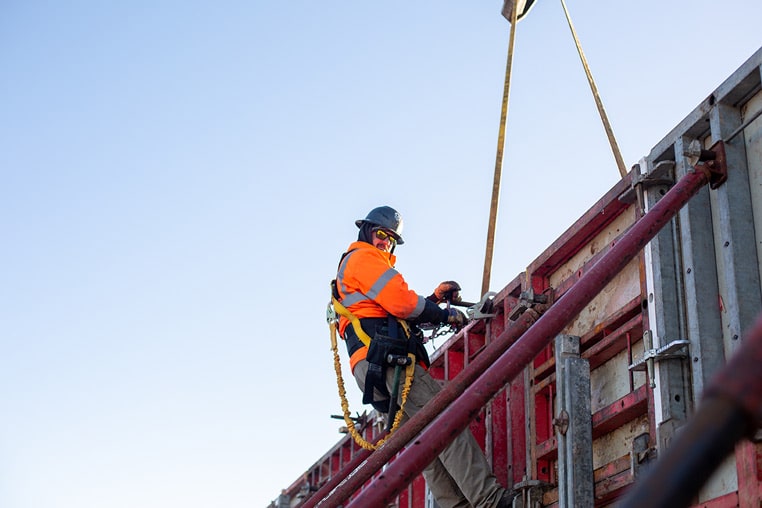 construction worker in harness working on building